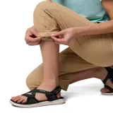 Pantalón de trekking convertible para mujer, color beige, con diseño desmontable que permite transformarlo en shorts. Cuenta con rodillas articuladas, múltiples bolsillos funcionales, presillas para cinturón y dobladillo ajustable.