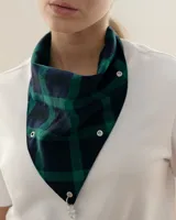 Bandana triangular de tela con estampado a cuadros en tonos verde y azul marino. Presenta ojales metálicos distribuidos en los bordes para la personalización con accesorios y un aro metálico en la punta inferior.