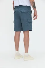 Bermuda cargo de gabardina color tostado, con bolsillos laterales y bolsillos cargo con solapa en las piernas. Calce relajado.
