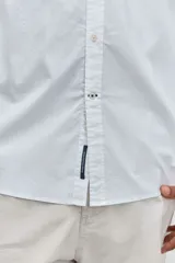 Camisa de manga larga en color celeste con estampado de rayas verticales finas, cuello abotonado y cierre frontal con botones.