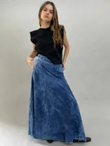 Falda larga de jean denim con efecto de lavado ácido y diseño de paneles geométricos cosidos. Presenta cintura alta, cierre lateral invisible y bolsillos ocultos, con un corte acampanado que aporta volumen y movimiento.