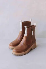 Botas de cuero color crema con cierre lateral y elástico en los laterales. Suela track color caramelo.