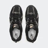 Championes New Balance 530 negros con detalles en beige y blanco.