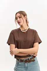 Remera oversize crop marrón de corte amplio y largo corto, con mangas cortas y cuello redondo.