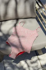 Traje de baño entero color rojo con estampado geométrico en blanco. Diseño con escote en U, tiras finas y corte debajo del busto.