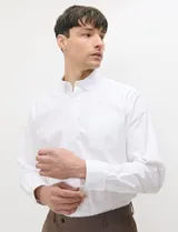 Camisa Oxford blanca de manga larga con cuello button-down, cierre frontal de botones al tono y un bolsillo aplicado en el pecho.