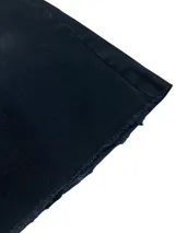 Bermuda de jean negra de corte ancho (baggy) y largo 3/4, con bordados de estrellas blancas en la parte inferior de la pierna izquierda.