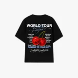 Camiseta oversize negra Nude Project, con estampa en la espalda que incluye el texto "World Tour", ciudades principales y un diseño de cerezas.