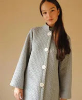 Bata de algodón capitoneado color gris claro, con cuello mao, corte recto, abotonada adelante y bolsillos laterales.