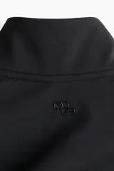 Campera deportiva corta de color negro con cierre frontal, cuello alto y mangas largas con abertura para el pulgar.