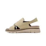 Sandalia plana Korium modelo Adamaris de color beige, confeccionada en gamuza con tiras cruzadas en el empeine, tira ajustable con hebilla metálica dorada y suela dentada en tonos beige y marrón.