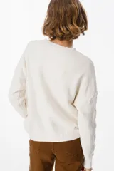 Sweater de punto negro con diseño de trenzas verticales en el frente y cuello redondo. Presenta un corte holgado con puños y ruedo acanalados.