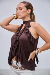 Blusa marrón con escote halter y volados en el frente, de corte asimétrico y holgado.