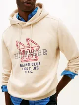 Buzo canguro Tommy Hilfiger de color blanco, con capucha ajustable por cordones y diseño gráfico deportivo en el pecho. Presenta un estilo urbano y relajado.