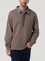 Buzo de hombre con cuello camisero y cierre frontal parcial con tapeta abotonada. Presenta mangas largas y un diseño minimalista con un pequeño logo bordado en el pecho.