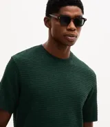 Remera de manga corta y cuello redondo, confeccionada en tejido de tricolina con textura acanalada. Presenta un diseño de corte clásico y ajuste cómodo.