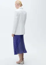Falda midi de corte recto con bajo asimétrico, tiro medio y cierre de cremallera lateral. Presenta un estampado de rayas diagonales en tonos azul, verde y blanco, e incluye un cinturón ajustable a juego con hebilla metálica.