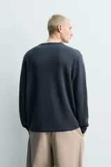 Jersey regular fit de mezcla de lino y lana, color gris oscuro, con cuello redondo y cierre frontal de botonadura tipo panadero, manga larga y acabados en rib.