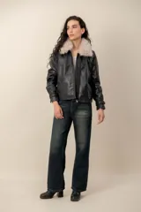 Campera de cuero negro con cuello desmontable de piel sintética en color celeste, cierre frontal y bolsillos laterales.