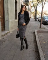 Vestido midi de punto con estampado animal print en tonos grises y negros, de corte recto, manga larga y cuello redondo. Cuenta con aberturas laterales en el ruedo y diseño adaptado para maternidad.