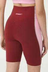 Biker deportivo color bordó y rosa, con cintura alta y costuras en tono verde.
