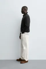 Jersey negro de punto perlado con cuello perkins y cierre frontal de cremallera.