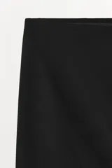 Falda mini de tiro bajo, confeccionada en tejido liso de color negro, con diseño minimalista y cintura elástica.