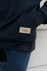 Buzo negro de algodón con cierre parcial en el cuello y bolsillo oculto.