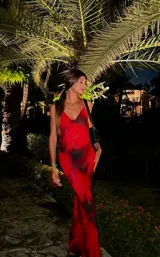 Vestido largo de microtul rojo con estampado abstracto negro, escote drapeado y breteles finos.