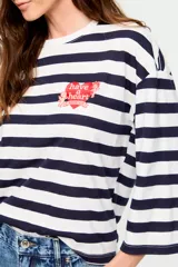 Remera de manga tres cuartos con diseño de rayas horizontales en blanco y azul marino, cuello redondo y silueta amplia. Incluye un pequeño estampado en el pecho con la frase 'have a heart' en forma de corazón.