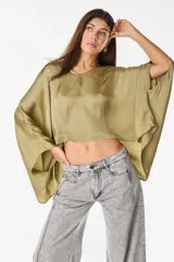 Blusa de algodón azul marino con escote en V, mangas murciélago amplias y diseño corto de corte asimétrico.