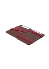 Billetera artesanal de cuero marrón oscuro con costuras en hilo rojo. Presenta un sistema de sujeción elástico en el lateral con detalles de colores (rojo, amarillo, azul) y ranuras para tarjetas en el exterior.