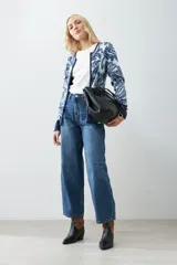 Chaqueta tejida color verde agua con estampado floral en azul marino, de corte recto y cuello redondo.
