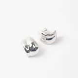 Par de caravanas tipo argolla gruesa con diseño abombado y acabado pulido brillante en color plateado.