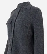 Campera de punto con textura, corte recto y cuello clásico. Presenta cierre frontal con botones y dos bolsillos aplicados con solapa en el pecho.