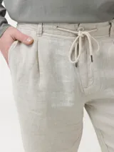 Short de lino organico color beige de calce relajado, con bolsillos laterales y cordón de ajuste en la cintura.