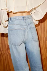Jeans de tiro alto con diseño de pierna extra ancha y larga. Presenta cinco bolsillos, cierre frontal con cremallera y botón metálico, con un acabado de lavado desgastado.