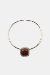 Collar tipo choker rígido de metal dorado con dije central cuadrado de resina marrón veteada, enmarcado por una hilera de cristales brillantes.