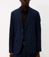 Saco de traje de lino y viscosa color beige, con solapa de muesca, cierre frontal de dos botones, bolsillos con solapa y medio forro interior.