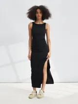 Vestido midi negro sin mangas, de corte ajustado con frunces laterales y abertura alta en la pierna.