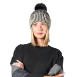 Gorro de lana con diseño de rayas verticales en blanco y negro, con borde doblado y pompón superior de pelo sintético negro.