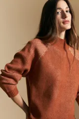 Polera de tejido acanalado en color marrón con detalles de líneas en tono lila, cuello alto y mangas largas con diseño raglán.