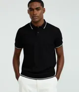 Remera polo de viscosa texturizada color negro con detalles contrastantes en blanco en el cuello, mangas y dobladillo. Diseño de corte regular con cuello polo y botones frontales.