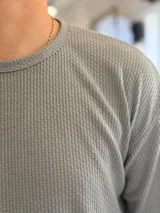 Remera oversize de tejido de punto color beige, de manga corta y cuello redondo.