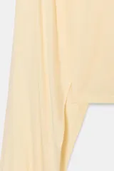 Top color amarillo claro con cuello alto, mangas asimétricas y bajo recto.