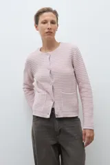 Chaqueta de punto color celeste, con cuello redondo, manga larga y cierre frontal con botones metálicos plateados.