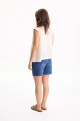 Blusa de viscosa negra sin mangas, con diseño fluido, cuello redondo y detalles de tablas verticales en el pecho con terminaciones de encaje en las sisas.