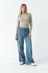 Body color visón con cuello tipo polera y mangas largas. Tiene frunces en los costados.