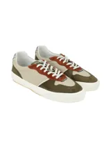 Sneaker de diseño moderno que combina cuero liso y texturado en tonos verde oliva, beige y detalles en color terracota. Presenta cordones blancos y un detalle metálico en el talón, con una suela de goma blanca de estilo plataforma.