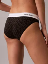 Bombacha clásica estilo bikini de Calvin Klein en color negro con monograma estampado en toda la prenda. Cuenta con una pretina elástica blanca con el logo de la marca en contraste.